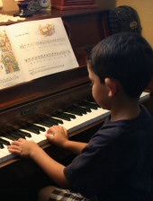Photo of Eli practicing the piano