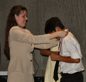 Photo of teacher giving student his medal of honor